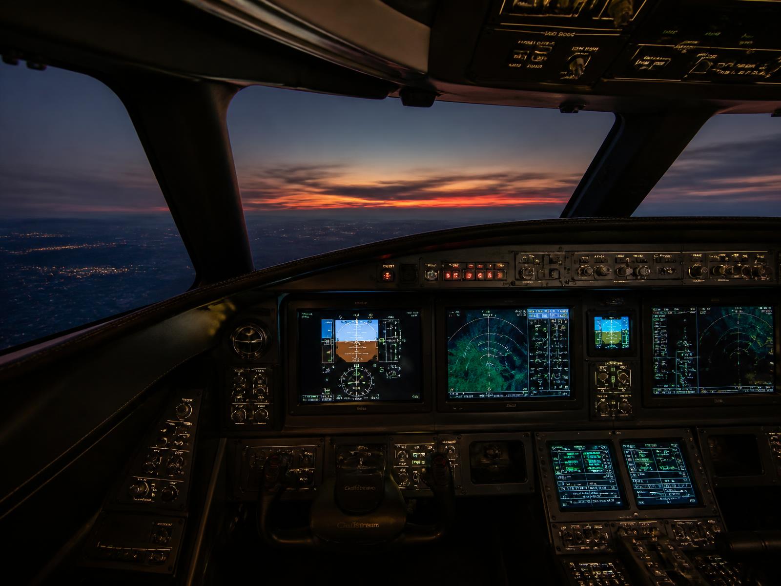 Cockpit de jato executivo com aviônica iluminada ao entardecer